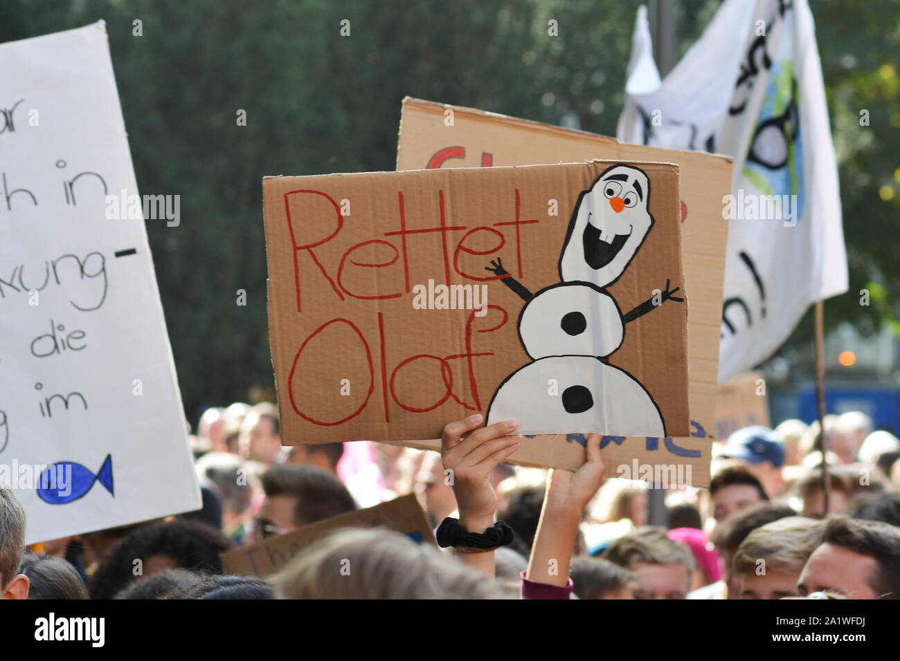 Protest sign with snow saying `Safe Olaf` held up by young people during Global Climate Strike / Fridays for future Stock Photo